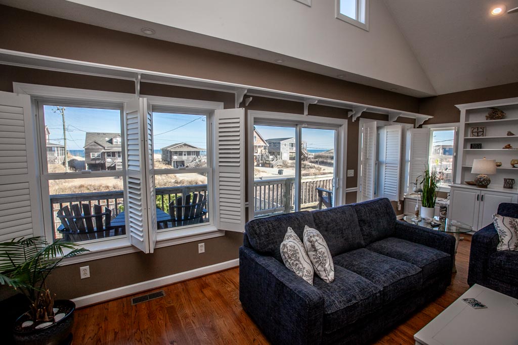 Living room with large windows and a view of a waterfront neighborhood.