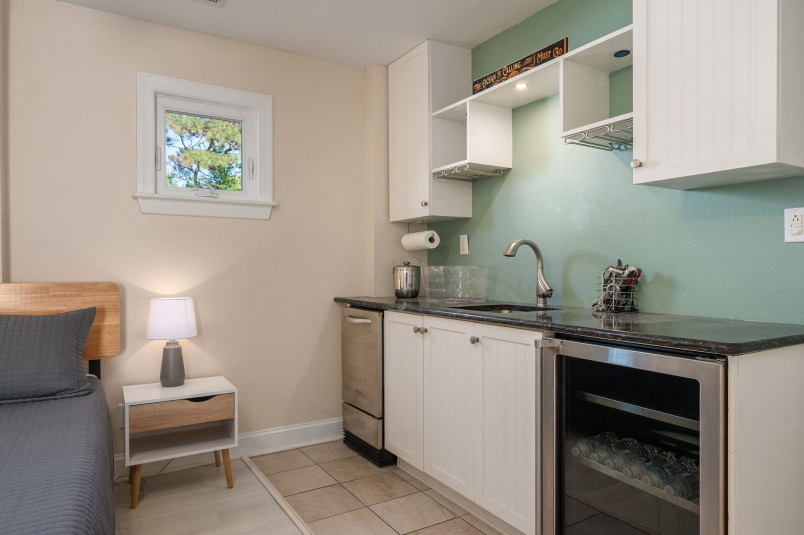 Compact kitchen with white cabinets and mint green backsplash.