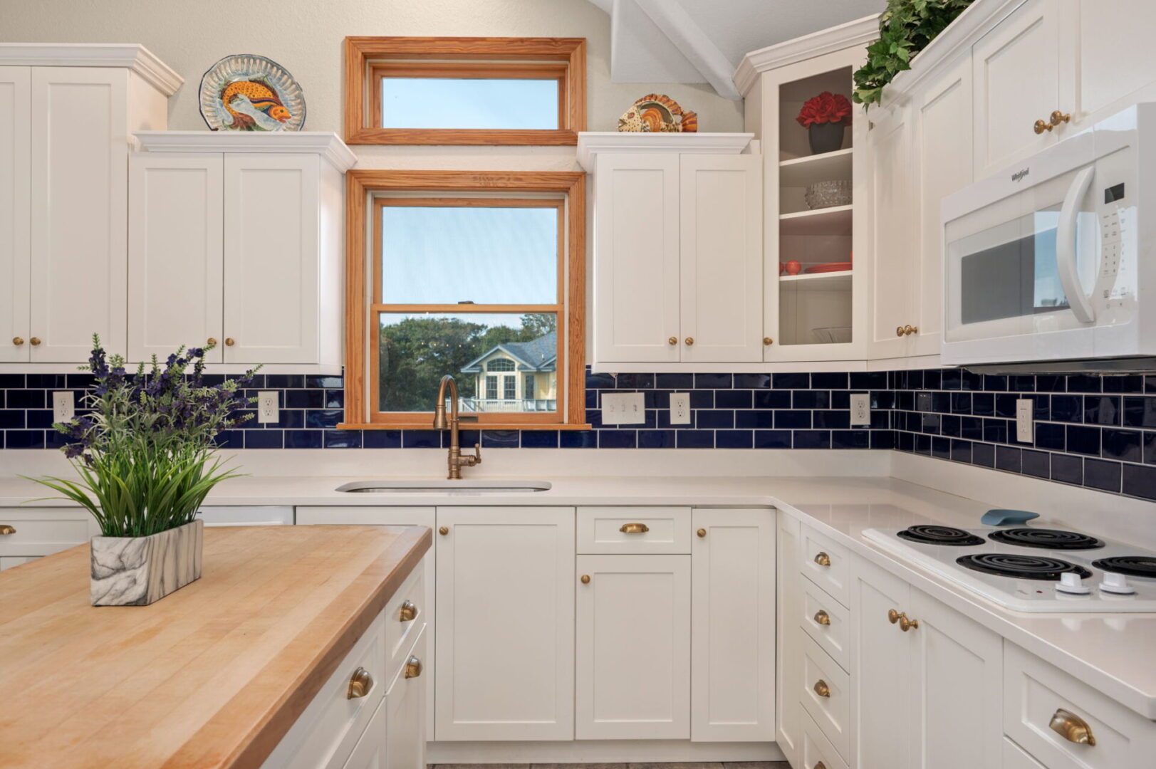 Bright kitchen with white cabinets and a wooden window frame.