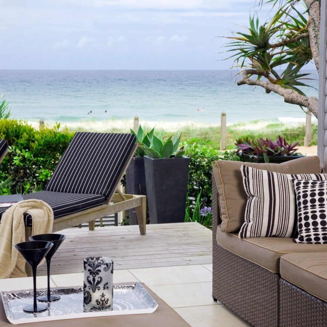 Cozy outdoor patio with ocean view and modern furniture.